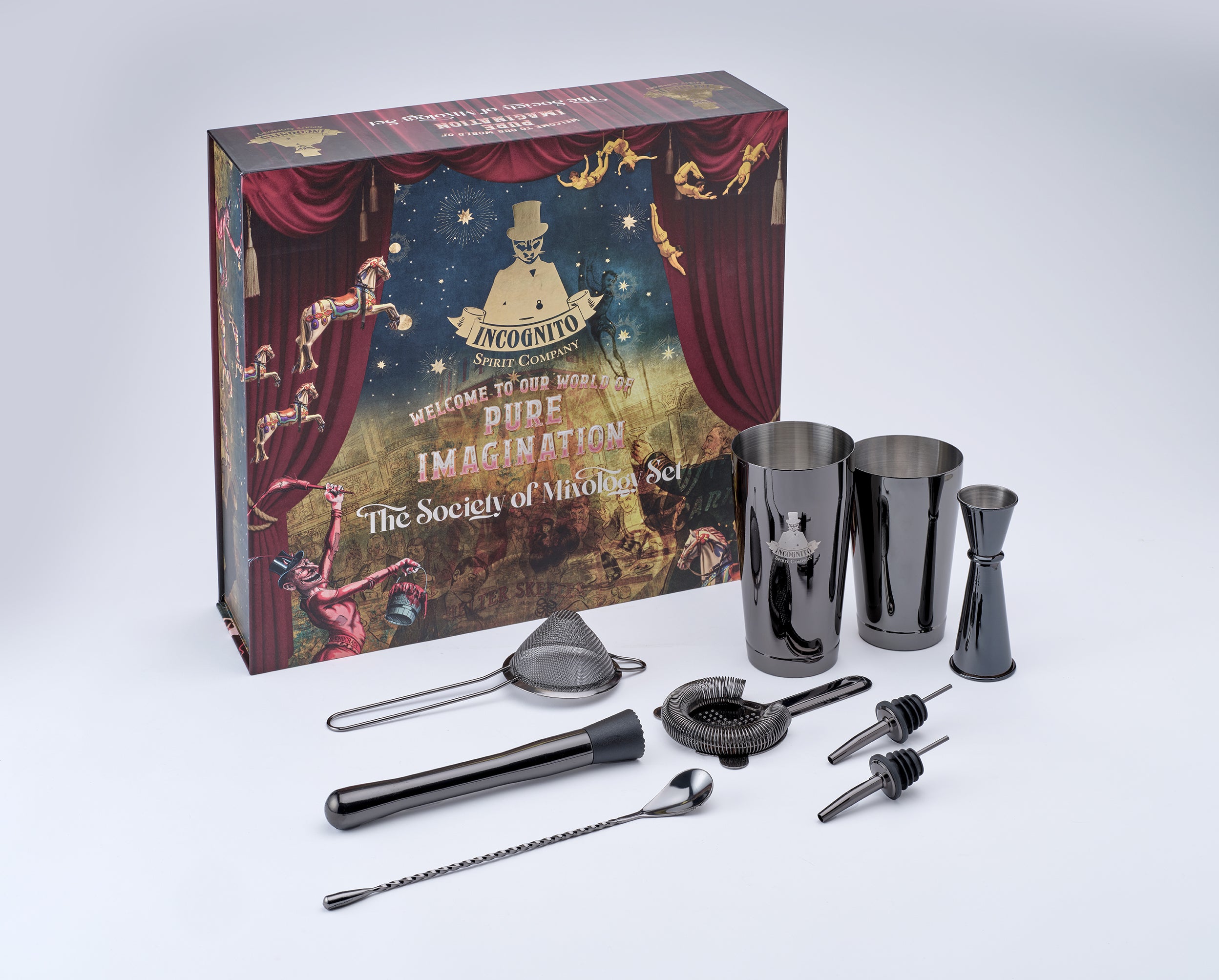 A cocktail mixing set displayed in front of its illustrated product box on a light gray studio background. The set includes stainless steel cocktail shakers, a jigger, strainer, muddler, bar spoon, and pourers, with the branded box behind them.