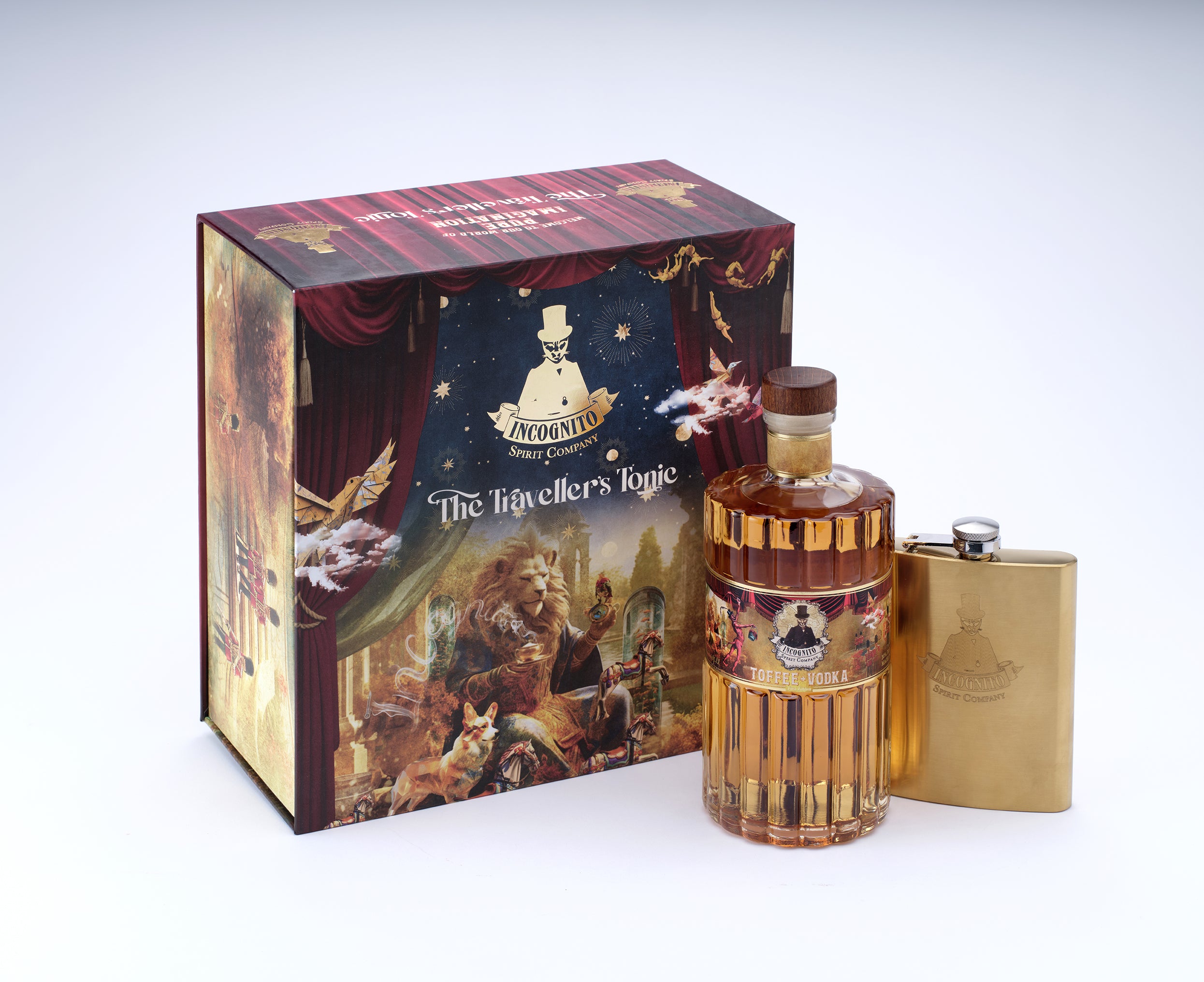 A bottle of amber-colored liquor with a gold-toned flask and a decorative illustrated gift box. The box features theatrical curtain imagery and the text 'The Travieller's Logic' and 'A Nightingale's Love'.