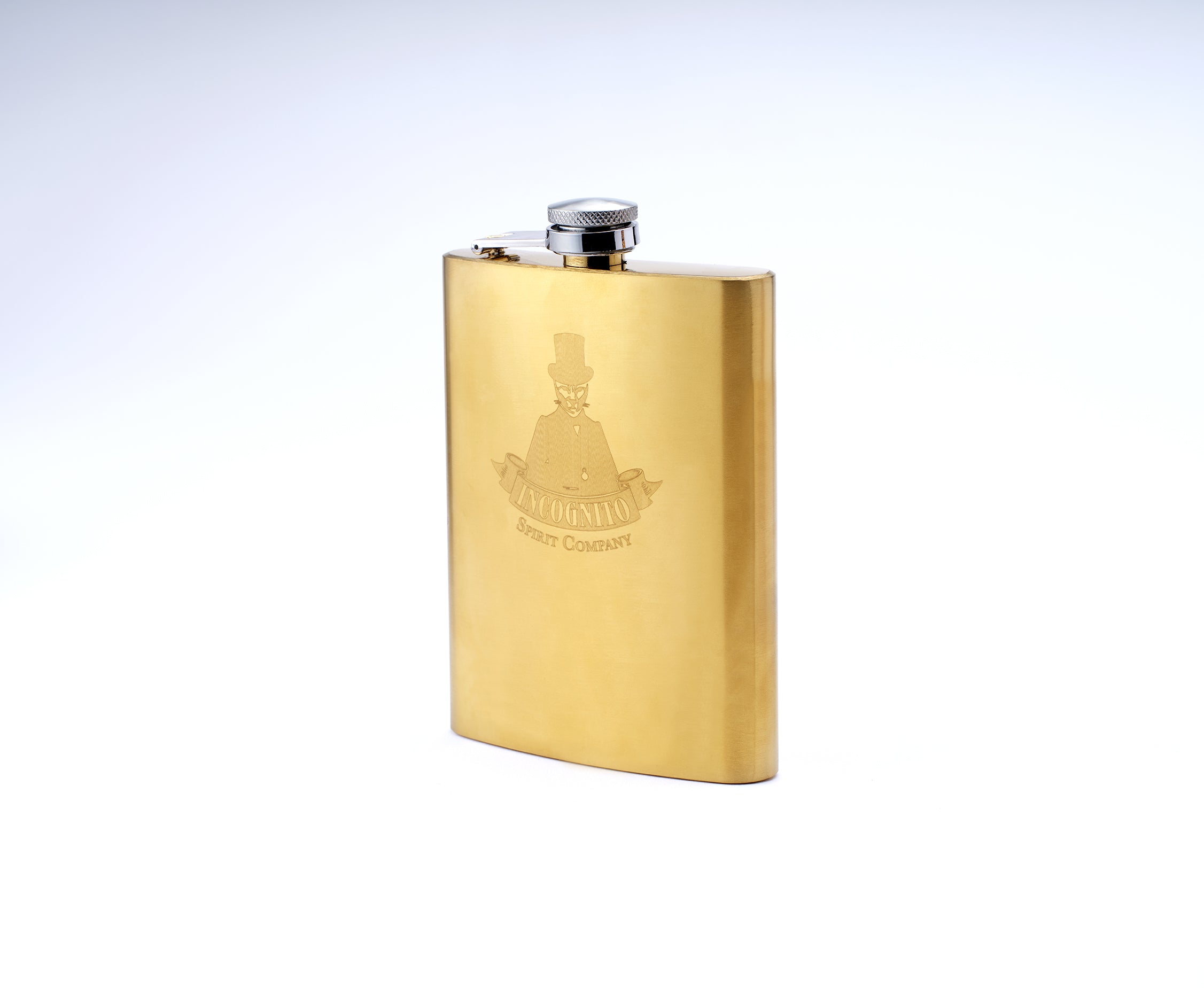 A gold-colored metal flask with a silver screw cap, featuring an engraved Incognito Spirit Company logo