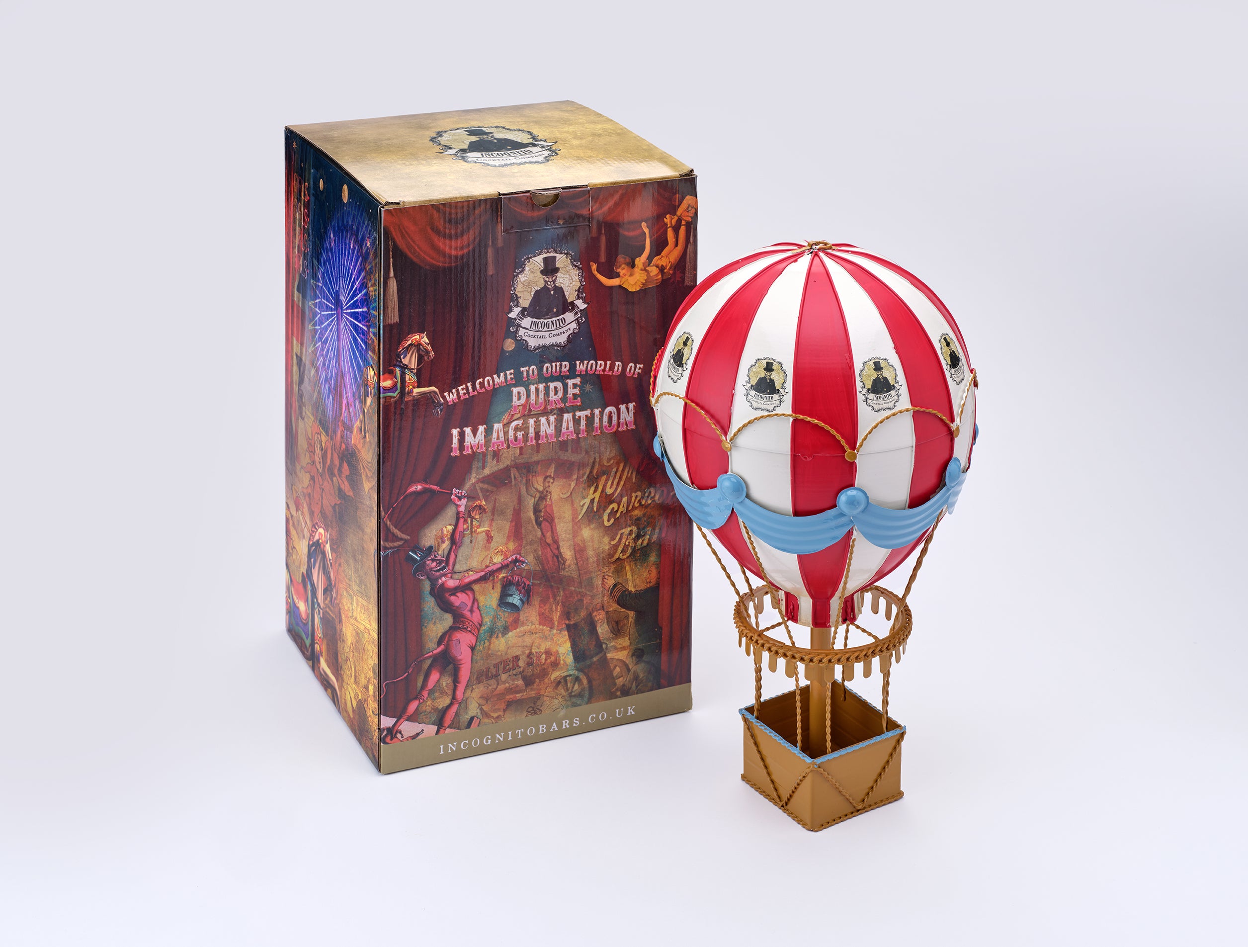 A red and white striped hot air balloon figurine with blue accents stands next to its illustrated product box on a clean white background. The box features fantasy artwork and the text 'Welcome to our world of Dope Imagination'.
